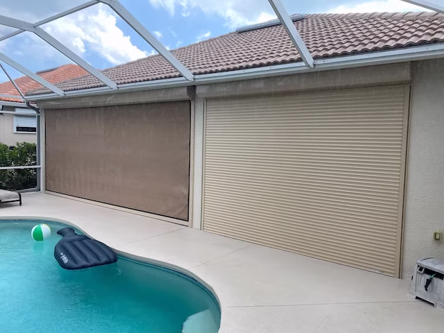 A hurricane home featuring a motorized roll-down screen alongside a heavy-duty aluminum roll-down shutter for maximum protection.