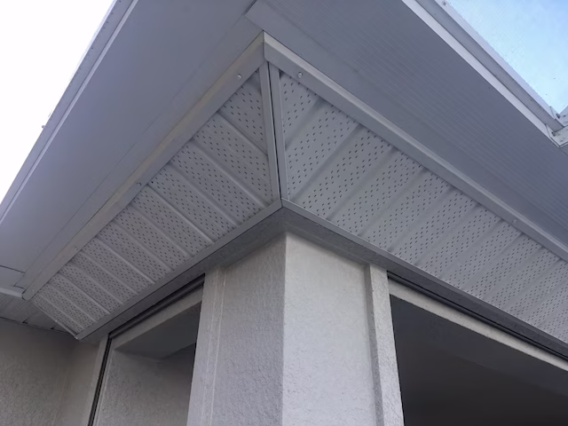 Two roll down hurricane shutters integrated into a white stucco soffit, showing a hidden and seamless installation that matches the home exterior.